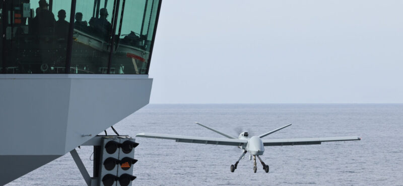 Image of the Mojave unmanned aerial vehicle (UAV), seen here landing on the flight deck of HMS Prince of Wales.

On 15th November 2023, Codenamed “Mojave”, the specially modified remotely piloted aircraft successfully launched from, and then safely landed back onto, the deck of HMS PRINCE OF WALES in a unique trial off the East Coast of the United States of America. A European first, this trial further unlocks the potential of the UK’s Queen Elizabeth-Class aircraft carriers – designed and principally built around the F-35B Lightning stealth fighter – by demonstrating how modern uncrewed air systems can operate alongside 5th generation crewed aircraft.

After months of planning, successful trials of the largest uncrewed aircraft to ever launch from an aircraft carrier outside of the United States have paved the way for the next generation of air power to be delivered from the Royal Navy’s two supercarriers.

The Mojave trial marks the end of a successful series of experiments and tests with uncrewed aircraft to and from our aircraft carriers this autumn, and follows on from the successful demonstration in September when a small W Autonomous Systems logistics supply aircraft delivered supplies to HMS PRINCE OF WALES in the English Channel.  

The Mojave is an adaptation of the MQ1C Grey Eagle aircraft that has been developed for short take-off and landing (STOL), originally to prove STOL operations were capable at unprepared landing sits. With a 17m wingspan, the UAS is 6m wider than an F-35B Lightning steal fighter, and weighs 1.5 tonnes in its fully loaded configuration. The medium altitude, long endurance, remotely piloted aircraft can provided long-range surveillance and strike capability over areas covering many thousands of miles.